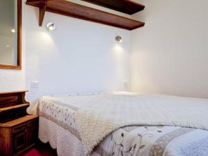 een slaapkamer met een wit bed en een houten dressoir bij Appartement La Tania, 3 pièces, 6 personnes - FR-1-513-37 in La Tania
