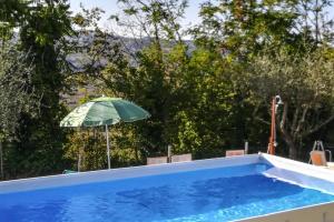 a swimming pool with an umbrella and a swimming pool at Holiday Home in Fano with Private Pool in Montemaggiore al Metauro
