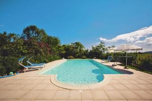 a swimming pool with two chairs and an umbrella at Country House in Monterado with Pool in Monterado +17 photos