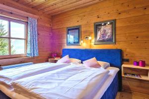 sypialnia z dużym łóżkiem w drewnianym pokoju w obiekcie Chalets in Eben im Pongau w mieście Eben im Pongau