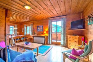 salon ze stołem i telewizorem w kabinie w obiekcie Chalets in Eben im Pongau w mieście Eben im Pongau