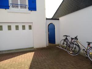 two bikes parked next to a building with a blue door at Apartment, Quimper in Quimper