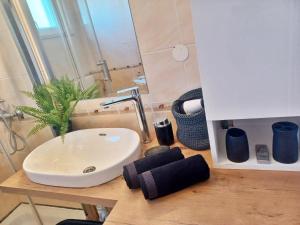 a bathroom sink with a plant on a wooden counter at Apartments Sonja Sevid in Sevid
