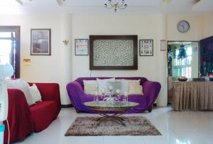 uma sala de estar com um sofá roxo e uma mesa em Villa Asuncion Country Inn and Resort Iloilo by RedDoorz em Iloilo