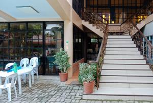 un patio con sillas blancas, una mesa y escaleras en Villa Asuncion Country Inn and Resort Iloilo by RedDoorz en Iloilo