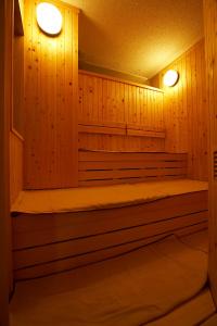 una sauna con paredes revestidas de madera y 2 luces en Dormy Inn Tomakomai en Tomakomai