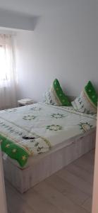 a bed with green and white sheets and pillows at Sweet Home in Iaşi