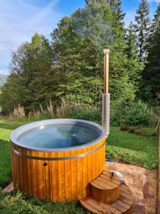 a wooden hot tub in a yard with a wooden deck at Luxus-Ferienhaus Blockhaus Chalet Nr 1 Toplage am Feldberg mit Sauna, Outdoor-Hottub, Kamin auf 1300m üM in Feldberg