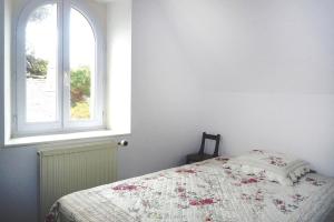 a bedroom with a bed and a window at Holiday Home Trebeurden by Pink Granite Coast in Trébeurden
