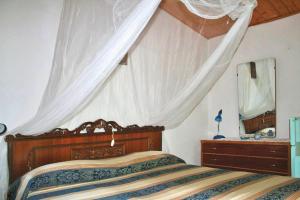 una camera con letto a baldacchino e specchio di Holiday home Fiorenzuola Acacie, Montemaggiore a Montemaggiore al Metauro