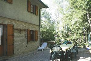 un patio con mesa y sillas junto a un edificio en Holiday home Fiorenzuola Acacie, Montemaggiore, en Montemaggiore al Metauro