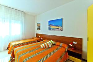 two twin beds in a bedroom with a window at Holiday resort Condominio Eden in Bibione