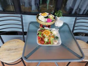 a glass table with a plate of food on it at ต้งโฮมหละปูน in Lamphun