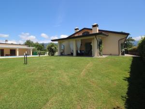 une maison avec une grande pelouse devant elle dans l'établissement holiday home, Camaiore, à Camaiore