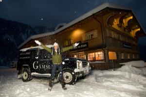 Eine Frau steht im Schnee vor einem Gebäude in der Unterkunft Gämsle Hotel, Wirtshaus & mehr in Schoppernau