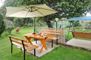 a picnic table with an umbrella and two benches at holiday home, Kolczewo in Kołczewo