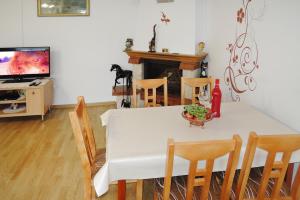 a dining room with a table and chairs and a television at holiday home, Kolczewo in Kołczewo