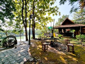 a picnic area with benches and a building with a lake at โอบสุขโฮมสเตย์ Oob-Suk in Ban Mae Cho