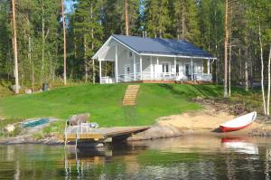 a house with a dock and a boat on the water at Kainiemen Huvilat in Nurmes