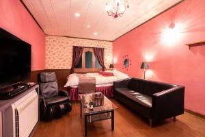 a living room with a bed and a couch at プレゼントホテル チャペルガーデン 可児 ｰ大人専用ｰ in Kani