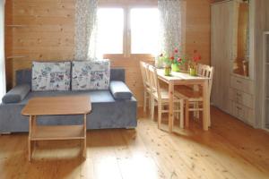 a living room with a couch and a table at Bungalow, Wrzosowo in Wrzosowo