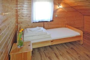 a bed in a wooden cabin with a window at Holiday resort, Rewal in Rewal