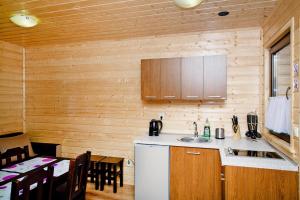a kitchen with wooden walls and a table and a sink at Holiday resort, Rewal in Rewal