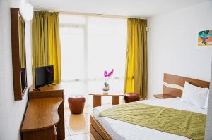a bedroom with a bed and a tv and a window at Hotel Mures in Saturn +22 photos