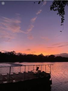 a boat sitting on the water at sunset at Egrets Rest in Daintree