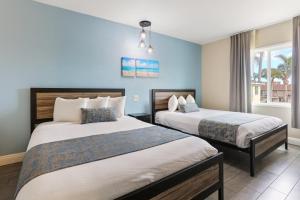2 camas en una habitación con paredes azules en Hotel Aqua Mar, en San Diego