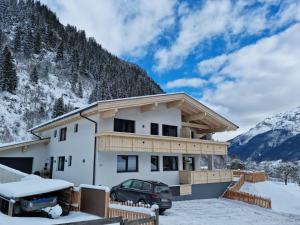 a house with a car parked in the snow at Apartment in Milders with Stubai SuperCard in Neustift im Stubaital