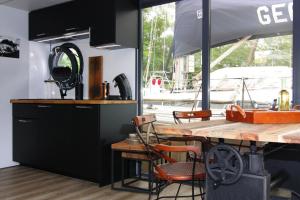 弗伦斯堡Houseboat in Flensburg with Harbor Views的厨房配有桌椅和船只