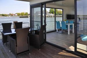a balcony with a table and chairs and a view of the water at Houseboat Floating House "Leni", Ribnitz-Damgarten in Ribnitz-Damgarten