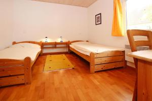 two beds in a room with wooden floors at Holiday resort in the M ritz National Park Mirow in Mirow