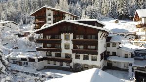 ein Hotel im Schnee mit schneebedeckten Gebäuden in der Unterkunft Apart - und Frühstückspension Jägerheim in Kaunertal