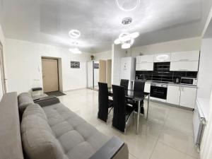 un soggiorno con divano, tavolo e sedie di Most City Area De-Lux Apartment a Dnipro