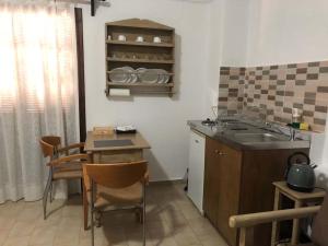 a kitchen with a sink and a table with chairs at Philoxenia Studios 3 in Karpathos Town