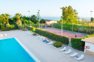 a tennis court with lounge chairs and a tennis court at Hotel Dei Pini in Porto Empedocle