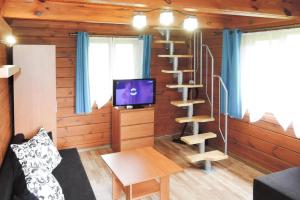un salon avec un escalier en colimaçon et une télévision dans l'établissement Holiday Home in Kolczewo near Baltic Sea, à Kołczewo 3 autres photos