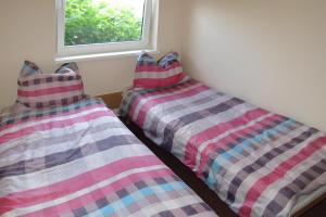 two beds sitting next to each other in a room at Holiday House in Szczecin at the lake with parking space for 4 persons in Szczecin