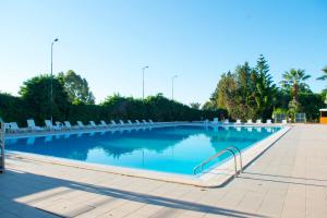 una gran piscina con sillas y agua azul en Hotel Dei Pini, en Porto Empedocle