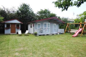 a small shed with a slide and a playground at Bungalow, Wrzosowo in Wrzosowo