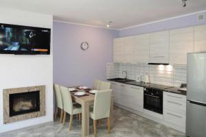 a kitchen with a table and chairs and a fireplace at Holiday flat, Lukecin in Łukęcin