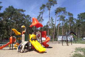 a playground with colorful play equipment in the sand at Holiday flat, Lukecin in Łukęcin