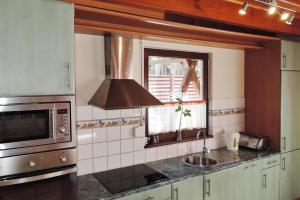 a kitchen with a sink and a microwave at holiday home, Lukecin in Łukęcin