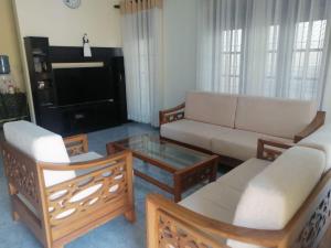 een woonkamer met een bank en een salontafel bij Lahiru Airport Villa in Andiambalama
