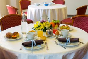 una mesa blanca con comida y bebidas. en Hotel Dei Pini, en Porto Empedocle