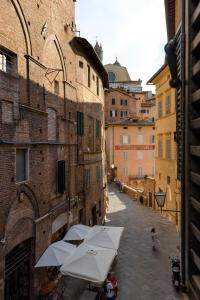 L'Azure Di Siena في سيينا: شارع فيه مظلات في زقاق فيه مباني