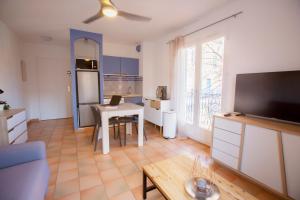 uma sala de estar com uma cozinha com uma mesa e uma televisão em SUN TROPEZ - Coeur du Golfe de Saint-Tropez em Grimaud