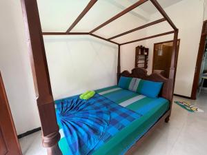 um quarto com uma cama de madeira com lençóis azuis em JAMI River Side Hotel & Yala Safari Place em Tissamaharama